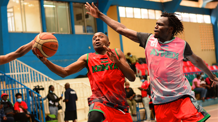 Okal tried to block Eric Mutoro's attempt at the basket during a training session at Nyayo :Photo courtesy